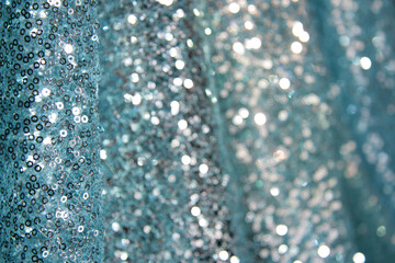 Blue fabric of shimmering sequins. Wavy drape, decorated with intricate embroidery work.