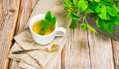 Cup of aromatic tea with mint on the table