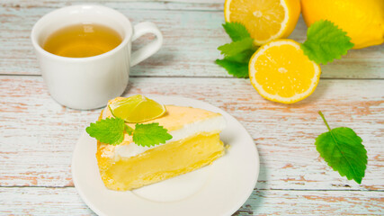Appetizing lemon pie, cup of tea and lemons on wooden background