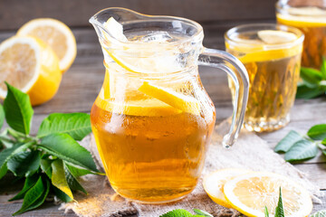 Glass jug of cold lemonade on table