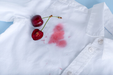 close up cherry stains from clothes. isolated on blue background