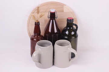 Beer bottles of different sizes and beer ceramic mugs empty mockup on white background.copy space for text.Packaging template design concept.
