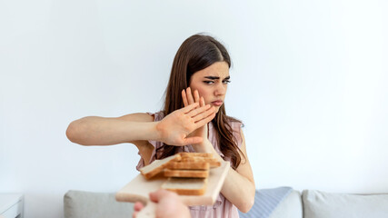 Cropped shot of a young woman on a gluten free diet is saying no thanks to white bread. Woman...