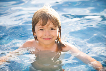 Happy boy playing and in swimming pool or sea water. Funny kids summer face.