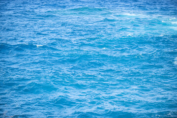 Obraz premium Calm sea water surface texture with splashes and waves. Abstract nature background. Background of aqua ocean water surface.