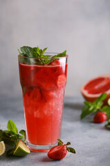 Summer. Soft drinks. Strawberry mojito with ice and mint, grapefruit and lime on a light gray background. Background image, copy space