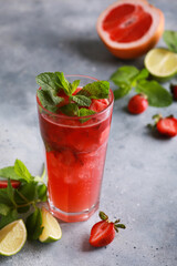 Summer. Soft drinks. Strawberry mojito with ice and mint, grapefruit and lime on a light gray background. Background image, copy space