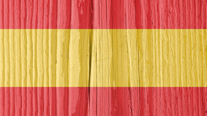 The flag of Spain on dry wooden surface, cracked with age. It seems to flutter in the wind. Background, wallpaper or backdrop with Spanish national symbol. Old wood. Hard sunlight with shadows
