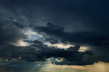 Naklejka na ściany i meble beautiful dark dramatic sky with sunlight and clouds as a background