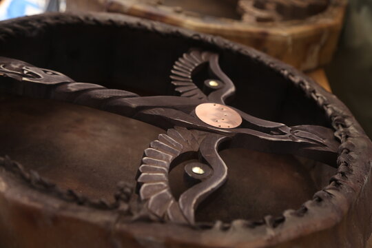 a wooden handle of a tambourine that looks like a flying bird. shamanic mood. shamanic drum