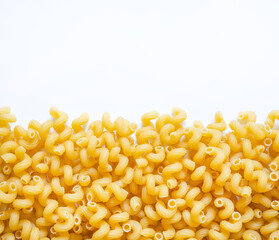 a lot of pasta in the shape of a spiral lies on a white background