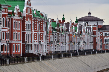 Gingerbread houses of red and white brick along the embankment. Russia Yoshkar-Ola 01.05.2021. High quality photo
