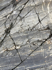 Close up of gray rock with diagonal cracks.