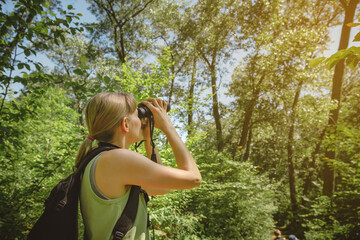 Young woman bird watching with binoculars at Indiana Dunes State Park - obrazy, fototapety, plakaty