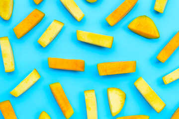 Tropical fruit, Mango slices on blue background.