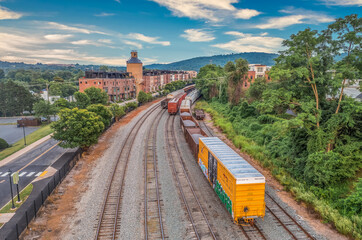 Aerial view of freight train parked on a railroad track next to a refurbished coal tower that is...
