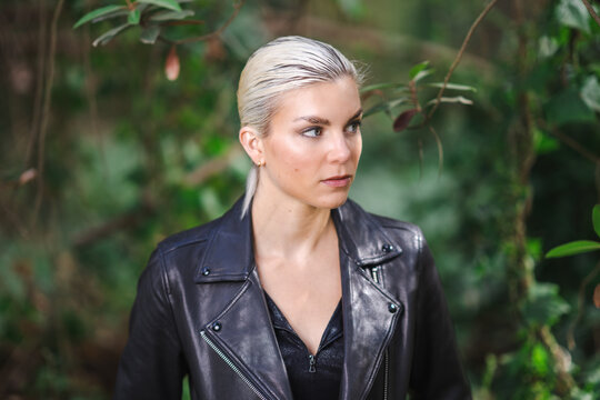 Tough Young Woman in a Black Leather Jacket Exploring a Forest Area
