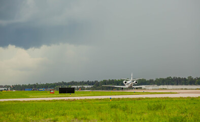 Fototapeta na wymiar Jet taking off into a dark cloud with rain in the distance