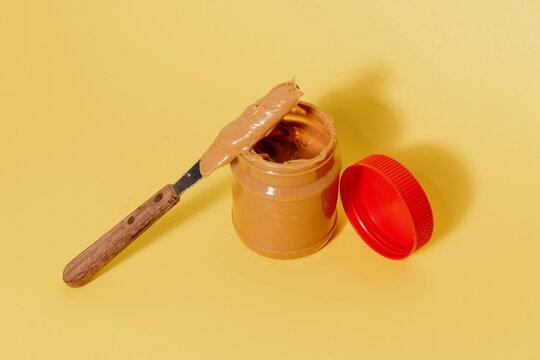 Opened jar of peanut butter with knife
