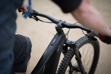 Man arms steering mountain bike handlebars black ebike MTB cycling strong exploring riding outdoors active fit exercise © LightItUp