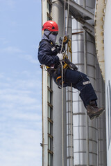 Male worker rope access  inspection of thickness storage tank industry