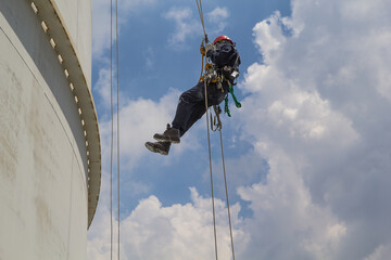 Male worker rope access  inspection of thickness storage tank