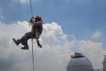 Male worker rope access  inspection of thickness storage tank
