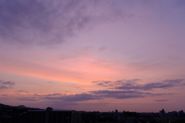 神戸市東灘区のマンション上層階から明け方の六甲山系。東の空から太陽が昇り空と雲がオレンジ色に染まる。六甲山と甲山の上雲の雲が美しい