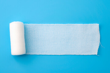 First aid, injury protecting wrapping and wound dressing concept clean cotton gauze bandage isolated on blue background with copy space - 441678325