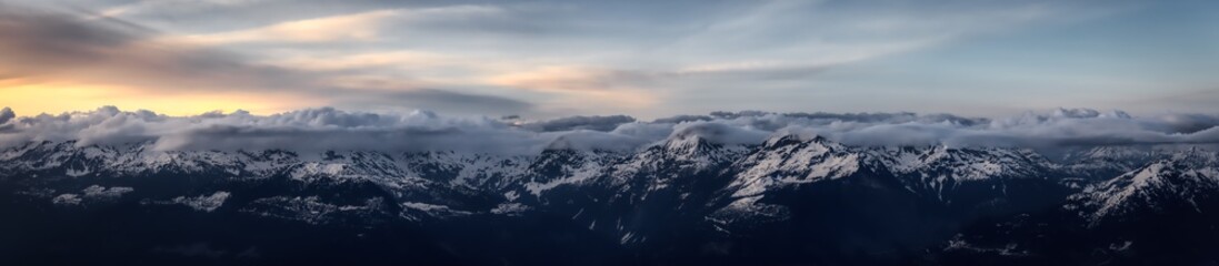 Aerial Panoramic View from Airplane of Canadian Mountain Landscape in Spring time. Colorful Sunset. North of Vancouver, British Columbia, Canada. Nature Panorama, Dark Moody Art Render