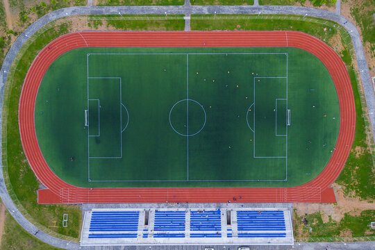 View from above. Sports stadium. Athletes are engaged in a green stadium.