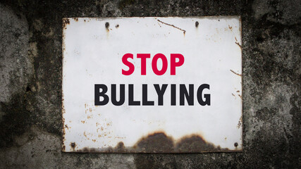 Stop Bullying, words on a grunge metal board on wall.