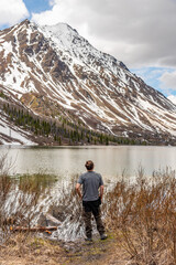 Hiker standing beside St Elias Lake in northern Canada during May after a easy day hike in Canadian wilderness. 