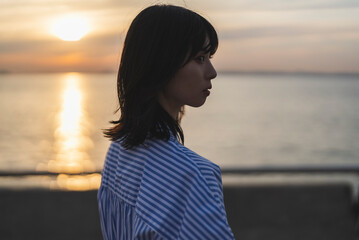 夕暮れの海にいる女性