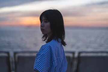 夕暮れの海にいる女性