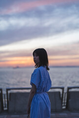 Fototapeta premium 夕暮れの海にいる女性