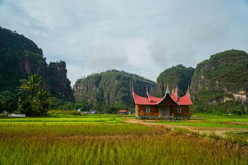 Minangkabau house/Rumah Gadang in a beautiful landscape view of Harau Valley with mountains valley and grass view, West Sumatra, Indonesia. Beautiful Minangkabau, Indonesia Landscape. © Ismail Rajo