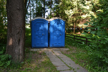 Portable Toilets By Road Against Trees