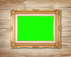 Obraz premium The antique gold frame on wooden wall background , for Graphics design.