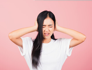 Asian portrait beautiful cute young woman have closed ears with hand palms and close eyes, studio shot isolated on pink background, Thai female covers ears for loud noise with copy space