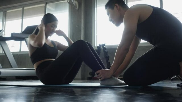 Athletic women exercise focus on specific parts of the body at gym indoors. Sportman sit-up for muscle sixpack at abdomen. woman healthcare while being quarantine at home.