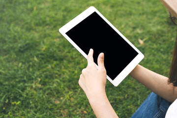 Traveler woman hand holding a digital tablet and touching on blank screen.