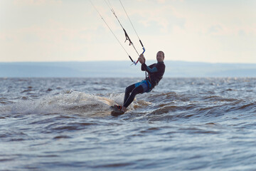 Kiteboarder surfing waves with kiteboard on a sunny summer day.