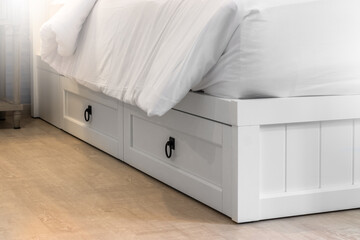 Close-up of white wood bed drawers in bedroom, minimal bedroom 