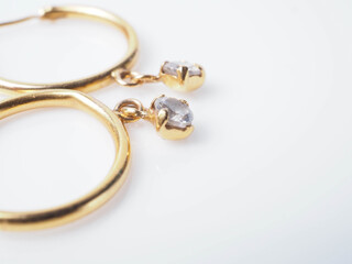 Close up shoot of a pair of golden earrings with diamonds