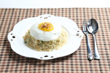 wok garlic olive fried rice with small silver fish seafood, fried egg and vegetables on white plate asian halal menu