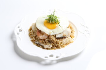 wok garlic fried rice with mixed seafood fish, prawn, squid, octopus, fried egg and vegetables on white plate asian halal menu