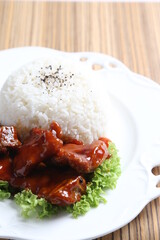 stir fried fresh pork, fish, chicken meat in sweet and sour ketchup tomato sauce serve with steam fragrant white jasmine rice and lettuce