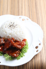 stir fried fresh pork, fish, chicken meat in sweet and sour ketchup tomato sauce serve with steam fragrant white jasmine rice and lettuce