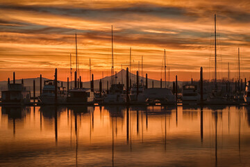 Sunrise on the Columbia River with Mt. Hood and a marina full of boat silhouettes against orange clouds